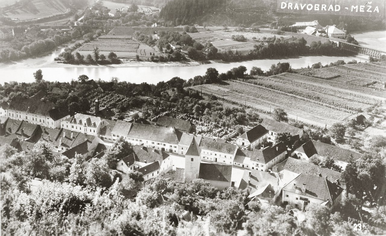 SKrajno desno je železniški most in Gollova rafinerija. Špicfeld je popolnoma prazen (razen starega pokopališča) in zasajeno polje, trg je makadam, spodnji grad (znan bolj kot Ojstrica) ima še prizidek, kjer je danes uvoz na šolsko dvorišče. Tudi na Meži na drugi strani ni prav ničesar, razen nekaj hišk.